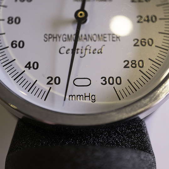 Sphygmomaneter gauge showing indicator needle left of oval at bottom of the gauge
